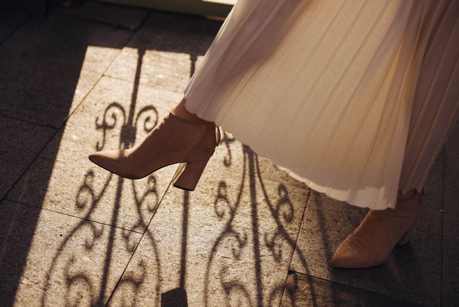 Stylish woman's boots casting intricate shadows in sunlight, showcasing elegance.