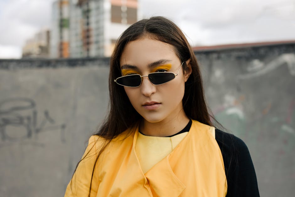 Portrait of a stylish young woman with sunglasses and bright fashion outdoors.