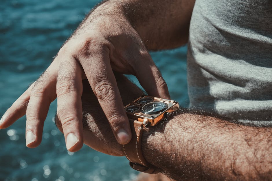 A close-up of a man adjusting his stylish wristwatch by the sea, showcasing detail and elegance.
