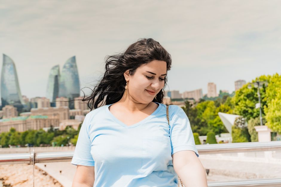 Portrait of a woman against the vibrant skyline of Baku, Azerbaijan and the Flame Towers.