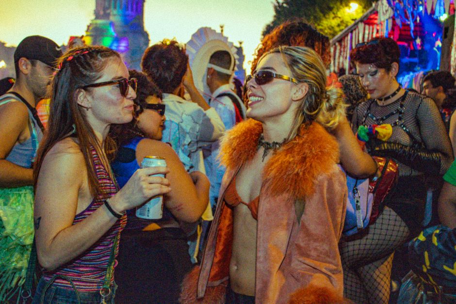 Colorful festival scene with people enjoying a lively street parade at night.