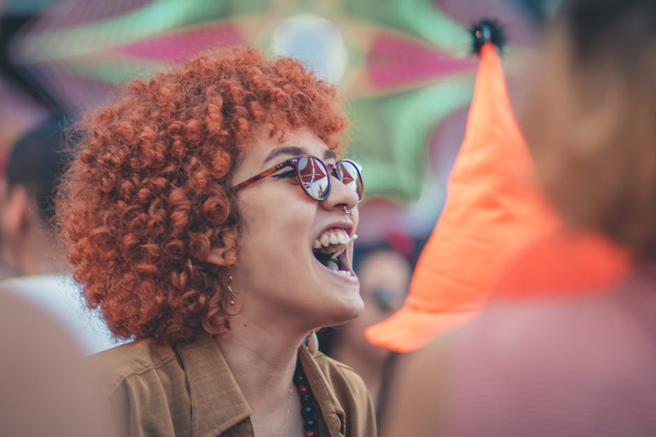 A vibrant scene of a smiling woman with curly hair enjoying an outdoor festival, exuding joy and liveliness.