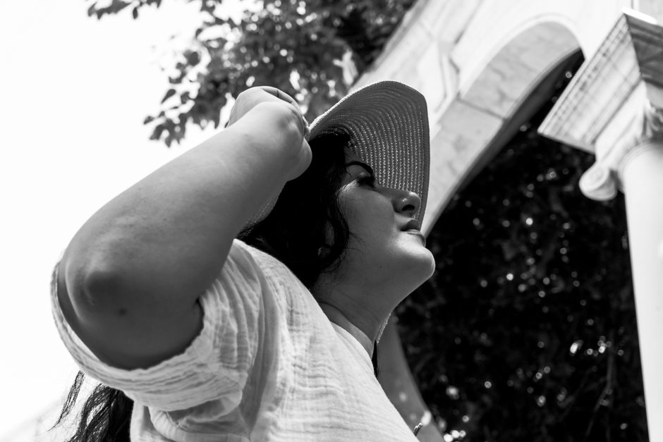Elegant black and white portrait of a woman wearing a sun hat, outdoors in Baku, Azerbaijan.