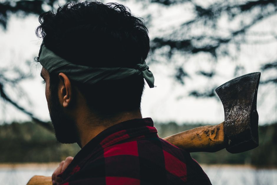A male hiker in Algonquin Park carrying an axe, outdoors and ready for adventure.