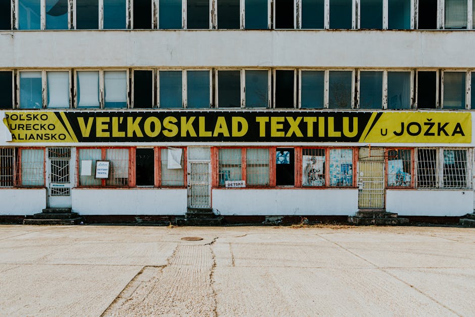 Old textile warehouse with a weathered facade and signage in an urban location.