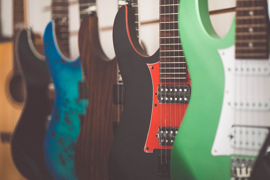Colorful electric guitars lined up in a music store display, highlighting different styles and finishes.
