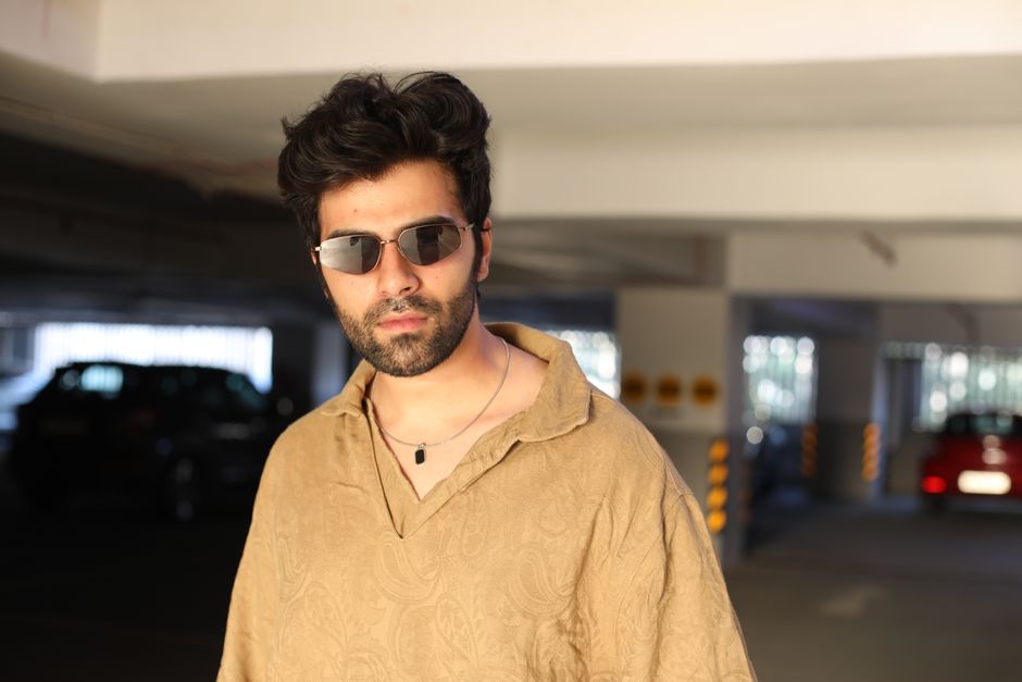 Stylish man wearing sunglasses in a parking garage with a confident look.