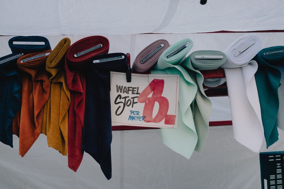 Vibrant waffle fabric rolls for sale at a street market in Maastricht, Netherlands.