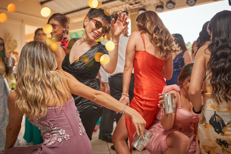 Women dancing and celebrating at an outdoor gathering, expressing joy and freedom in a vibrant atmosphere.